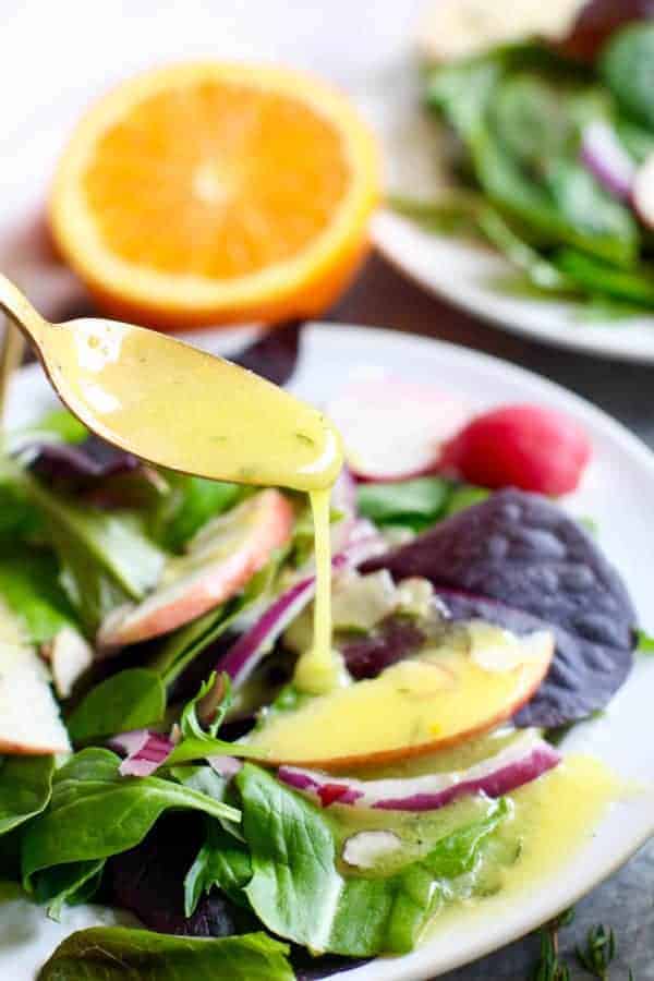 Citrus Vinaigrette with Thyme on a spoon dripping on a salad