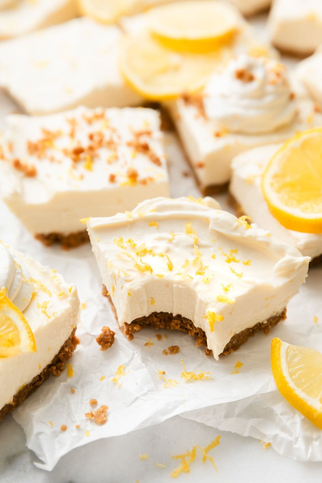 Close up view of a No Bake Lemon Cheesecake Bar with a bite taken out of it. 