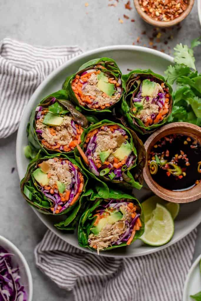 Overhead shot of slow cooker Hawaiian shredded chicken in chard wraps with fresh veggies tucked into the wraps with the chicken.