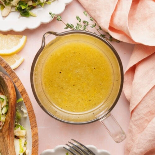 A liquid measuring cup full of citrus vinaigrette dressing.