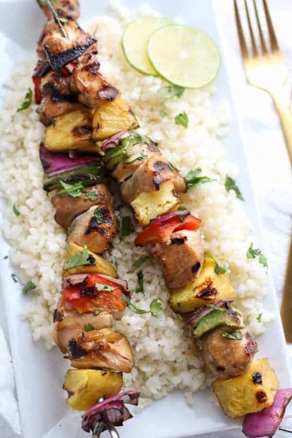 Teriyaki Chicken and Pineapple Kebabs over rice on a white plate