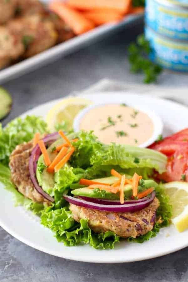 Easy Tuna Cakes with Roasted Red Pepper Mayo with toppings on a white plate