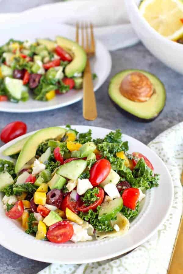 Greek Kale Salad with Avocado on a white plate