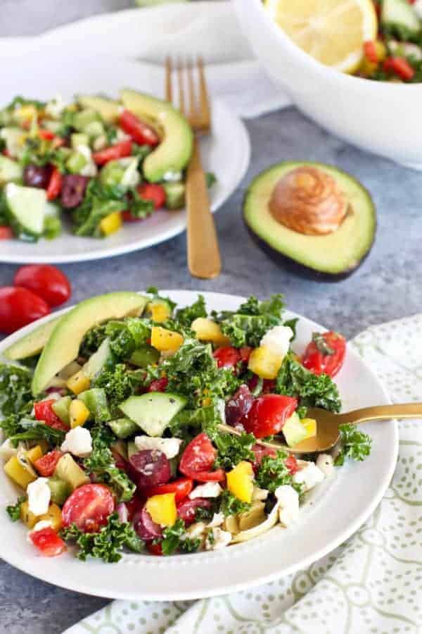 Greek Kale Salad with Avocado on a white plate