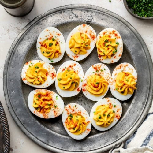 Healthy Deviled Eggs on a platter topped with paprika and chives