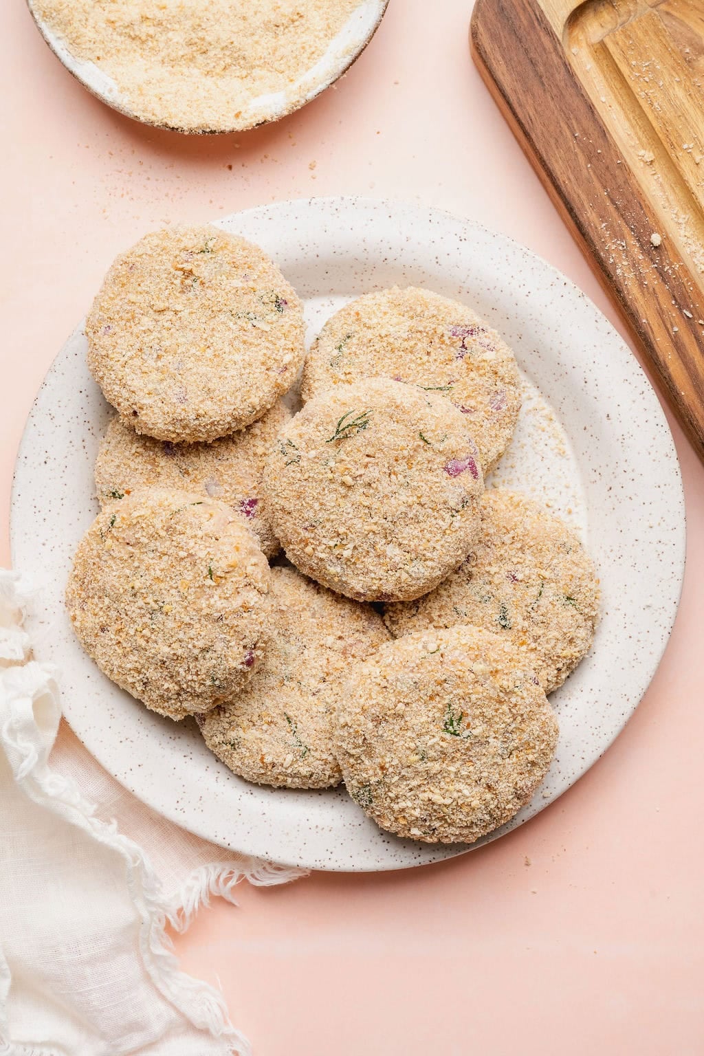 A plate of uncooked breaded tuna patties.
