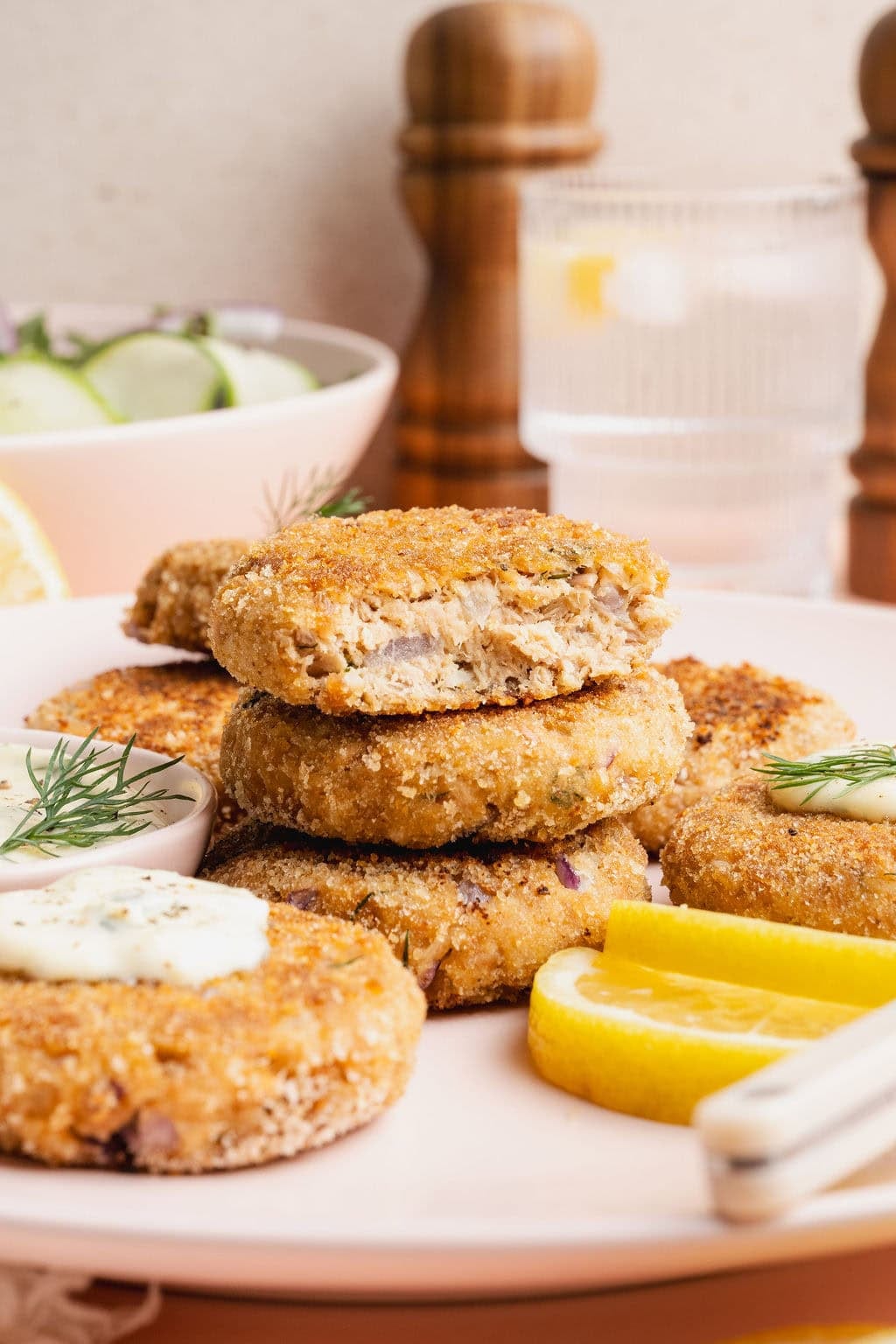 A plate of tuna patties, one missing half, exposing the center.