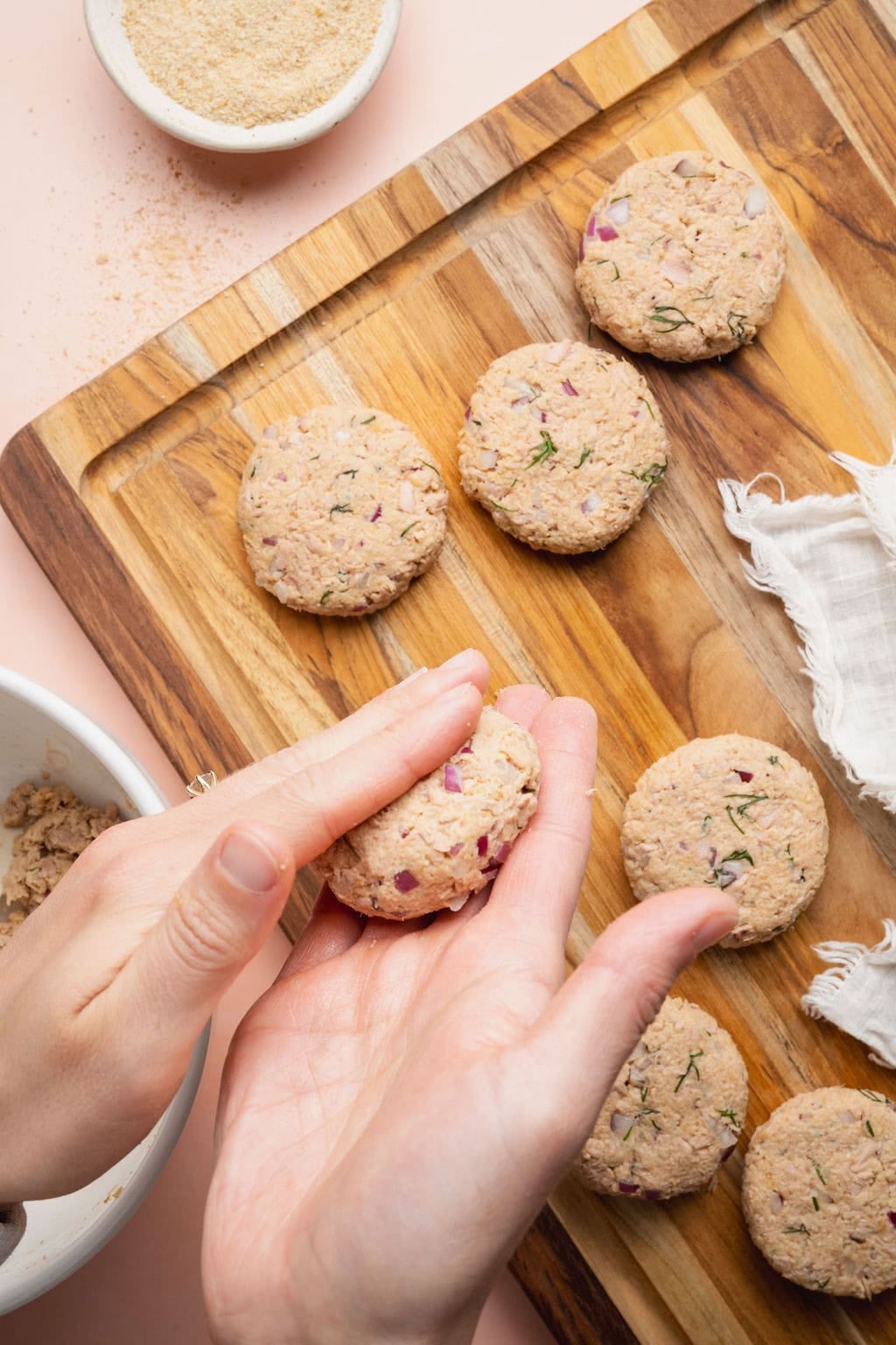 A woman's hand shaping tuna patties.