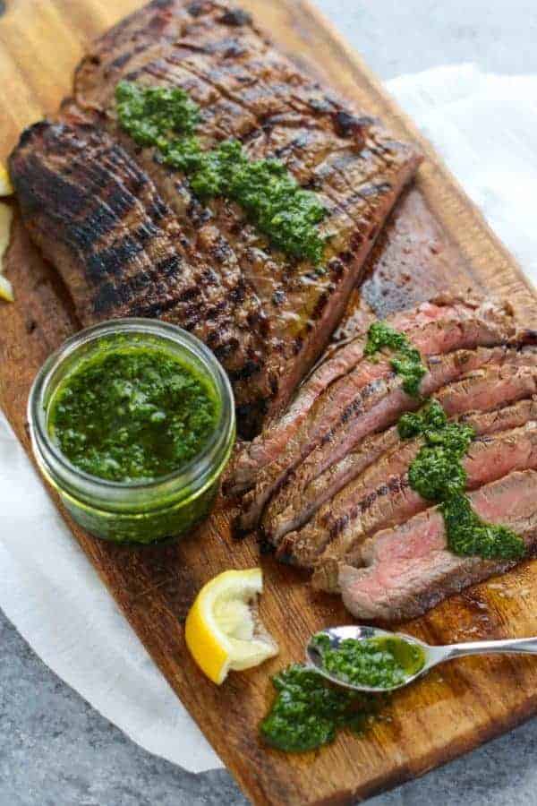 Balsamic Flank Steak with Chimichurri Sauce on wooden cutting board