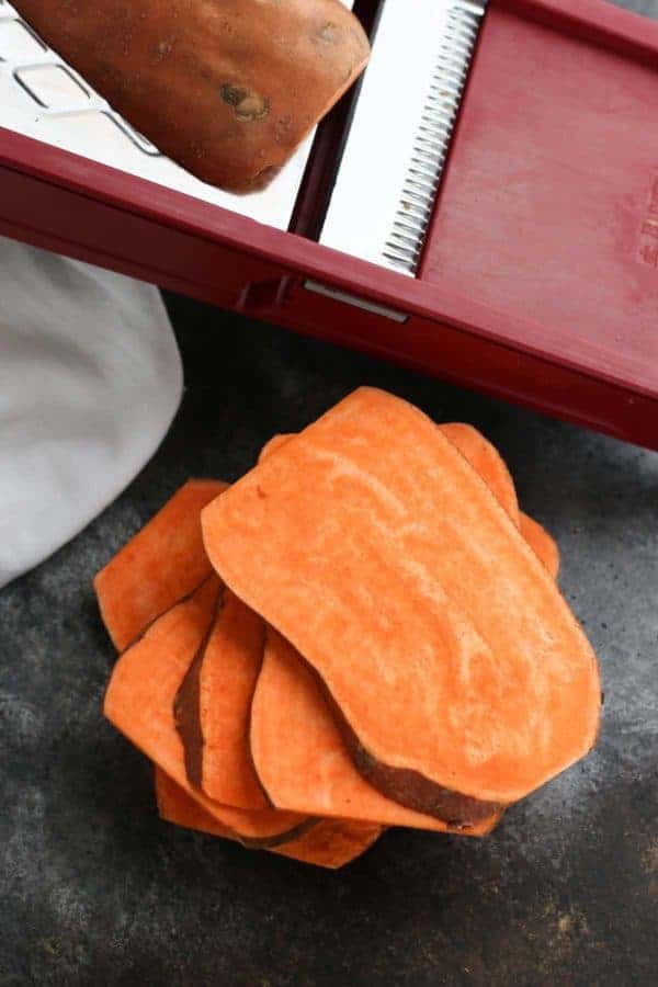Oven Baked Sweet Potato Toast 4 Ways sliced sweet potatoes in front of a mandolin on a counter top
