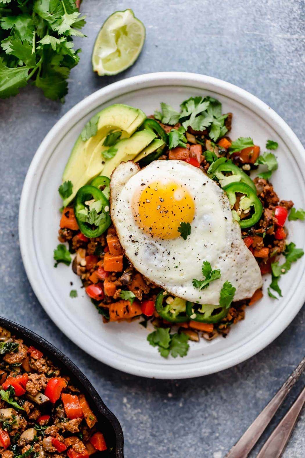 Tex-Mex Sweet Potato Hash served on a white plate with a fried-egg on top.