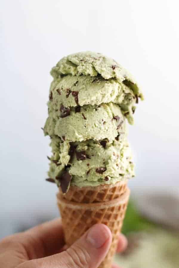 Four scoops of Dairy-free Mint Chocolate Chip Ice Cream on an ice cream cone