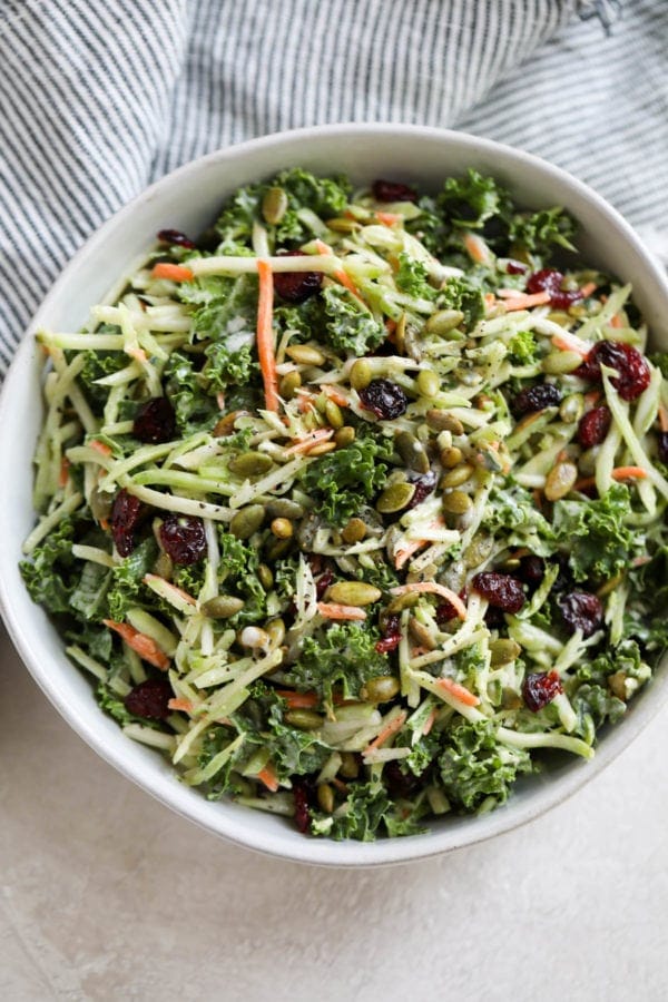 Creamy Gluten-free Broccoli Slaw with dried cranberries in a large white serving bowl.