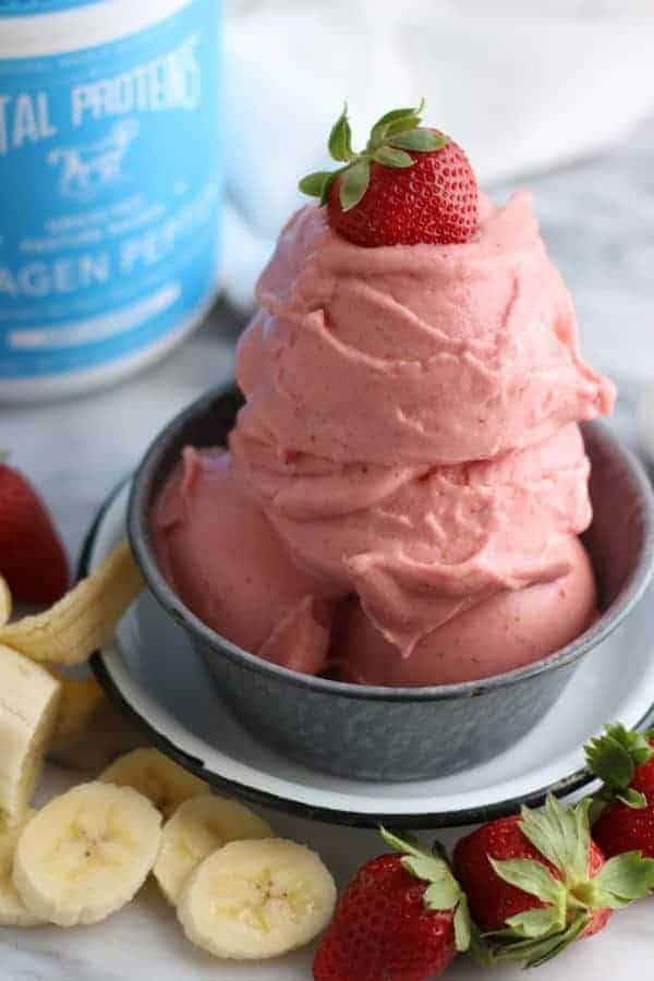 Strawberry Banana N'ice Cream in a silver bowl with sliced bananas and whole strawberries on the side