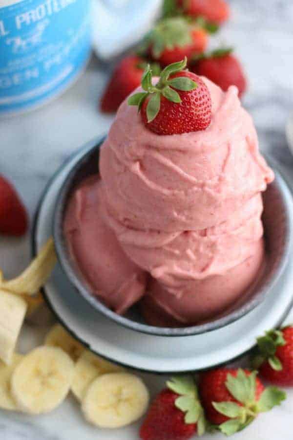 Strawberry Banana N'ice Cream in a silver bowl with sliced bananas and whole strawberries on the side