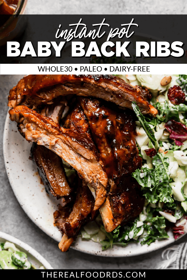 Baby back ribs covered in caramelized bbq sauce on a speckled plate with kale salad on the side