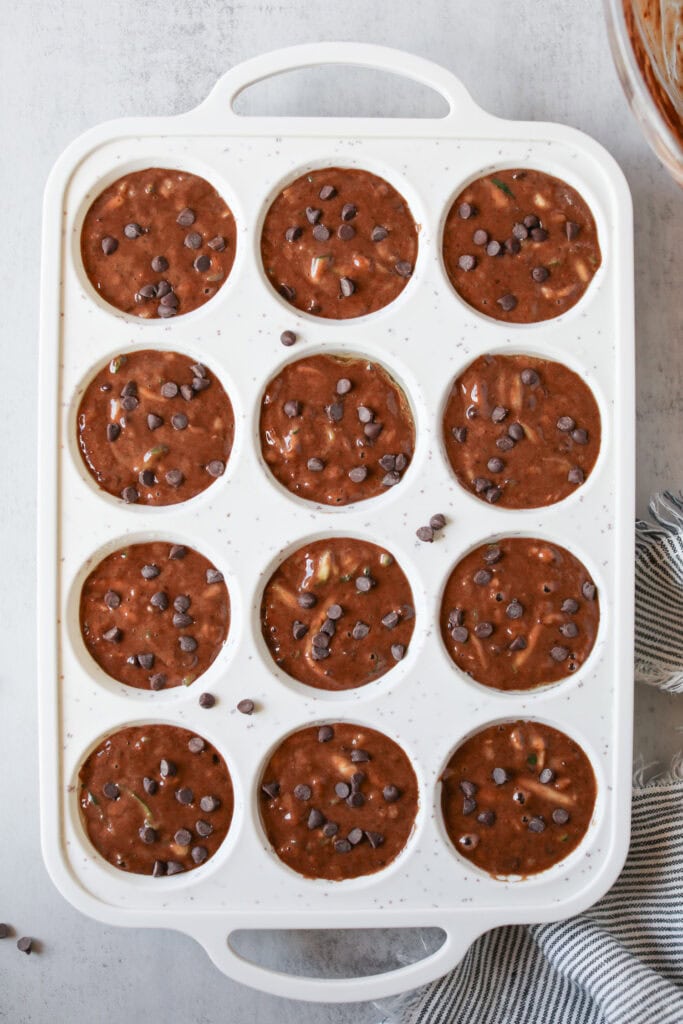 Overhead view of muffin pan filled with Double Chocolate Zucchini Muffin batter ready for baking. 