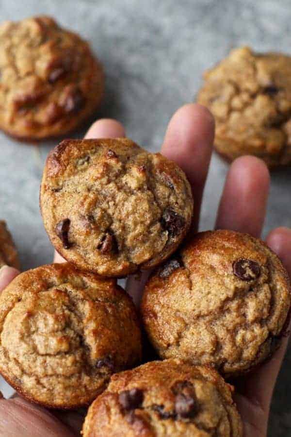 Banana chocolate chip mini muffins in a person's hand