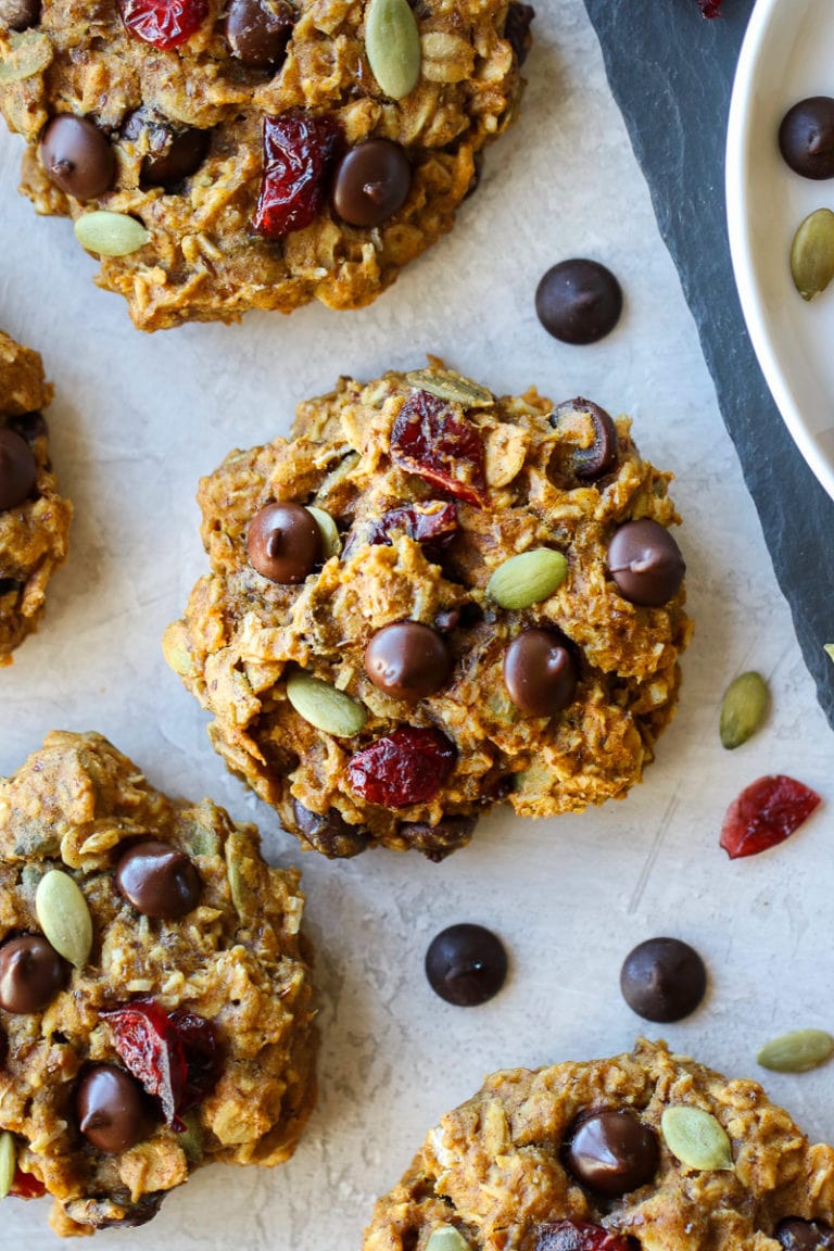 Close up view of pumpkin breakfast cookie topped with dark chocolate chips and dried cranberries.