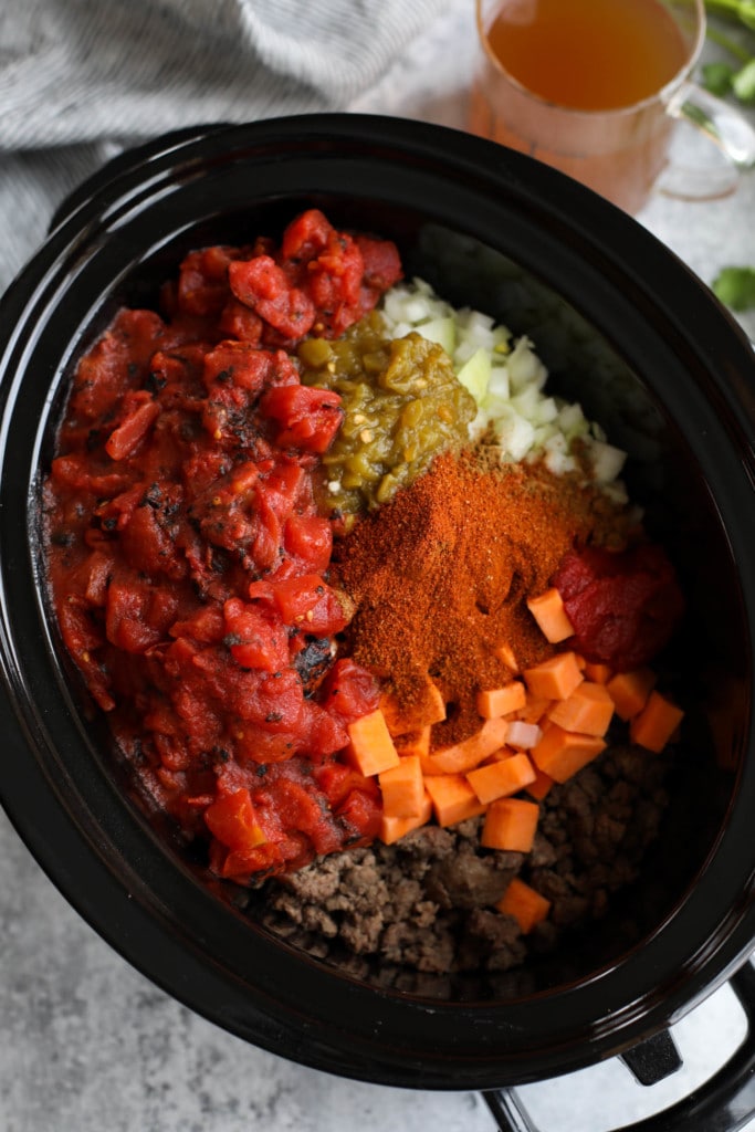 All ingredients for sweet potato chili in a black slow cooker