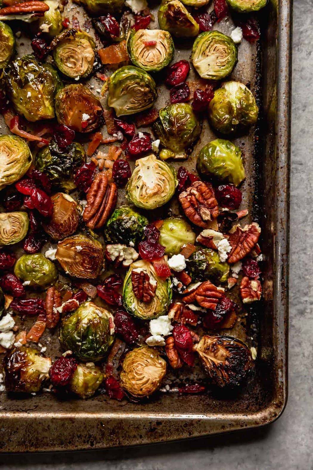 Roasted Brussels Sprouts with Bacon, cranberries, pecans and feta cheese on a pan for a Thanksgiving Menu