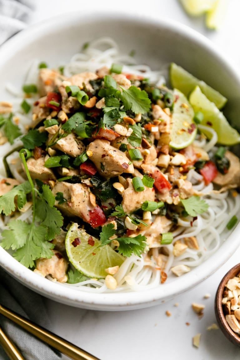 A bowl of Thai-inspired peanut chicken served over rice noodles.