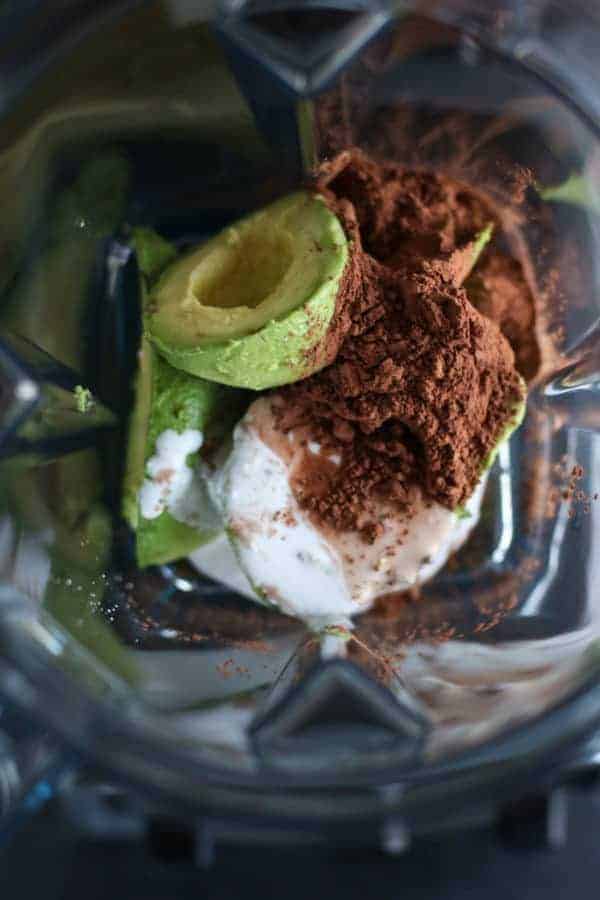 Avocados, cocoa powder and coconut milk in blender. 