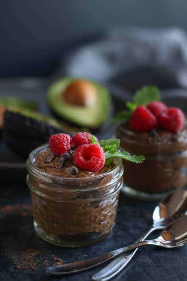 Chocolate mousse topped with fresh raspberries in a jar. 