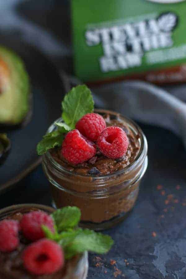 Chocolate mousse in cup with topped with fresh raspberries.
