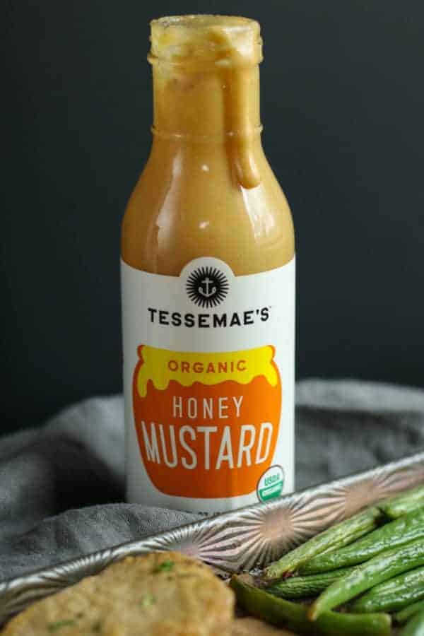 Bottle of Tessemae's Honey Mustard with drip running down the side. 