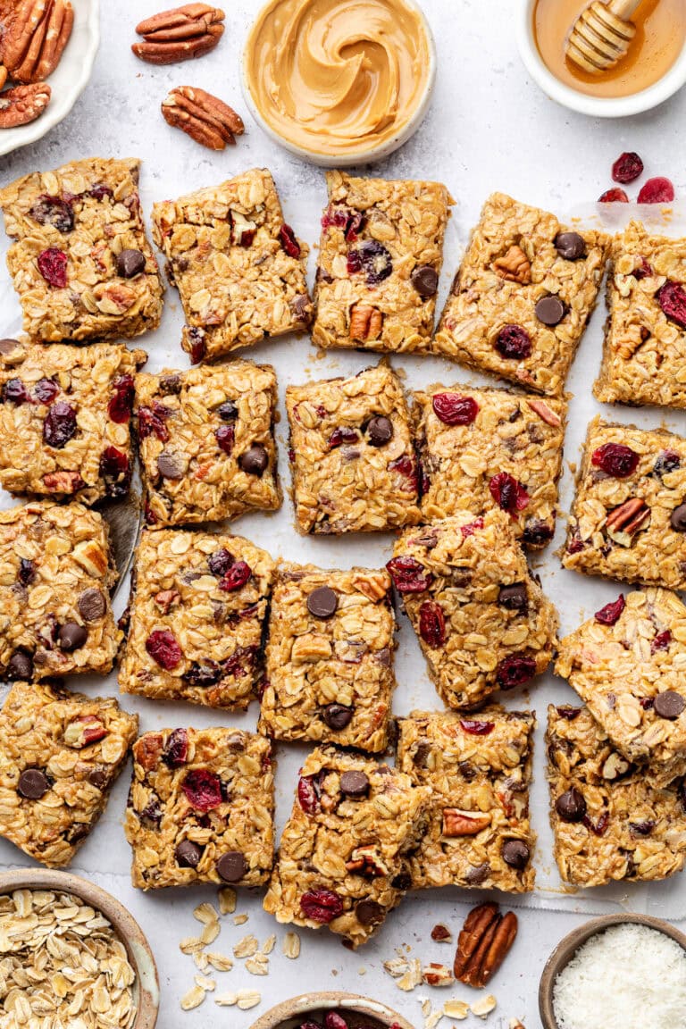 Overhead view of a batch of trail mix bars cut into squares showing pieces of chocolatenutsand dried cranberries.