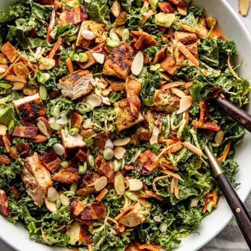 Overhead view of a colorful Chopped BBQ Ranch Chicken Salad topped with toasted almonds and green onions.