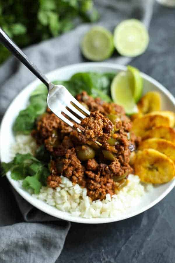 Slow Cooker Picadillo on a fork and on a white plate