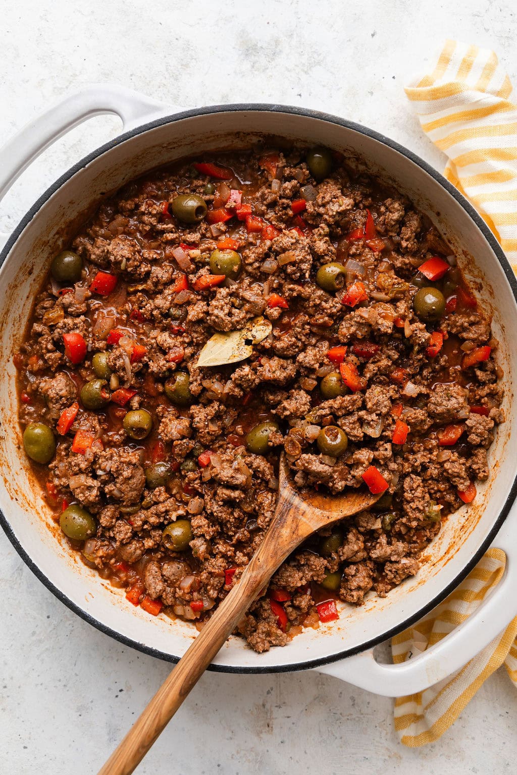 Overhead view of a skillet filled with Stovetop Picadillo and a bay leaf peeking out. 