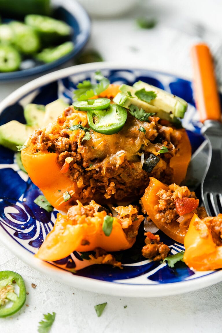 A Taco Stuffed Bell Pepper cut into on a plate showing the yummy filling inside. 