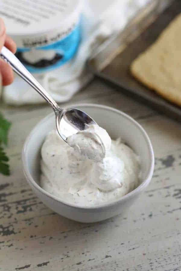 Sour cream in a bowl and on a silver spoon