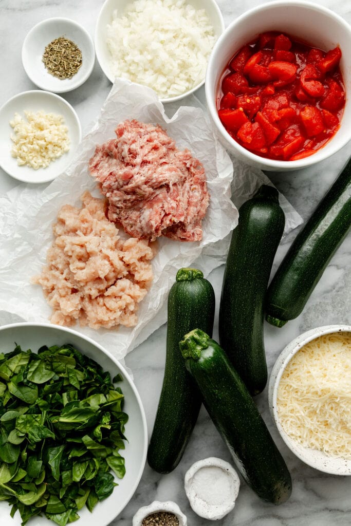Overhead view of variety of ingredients for Delicious Italian-Sausage Stuffed Zucchini Boats. 