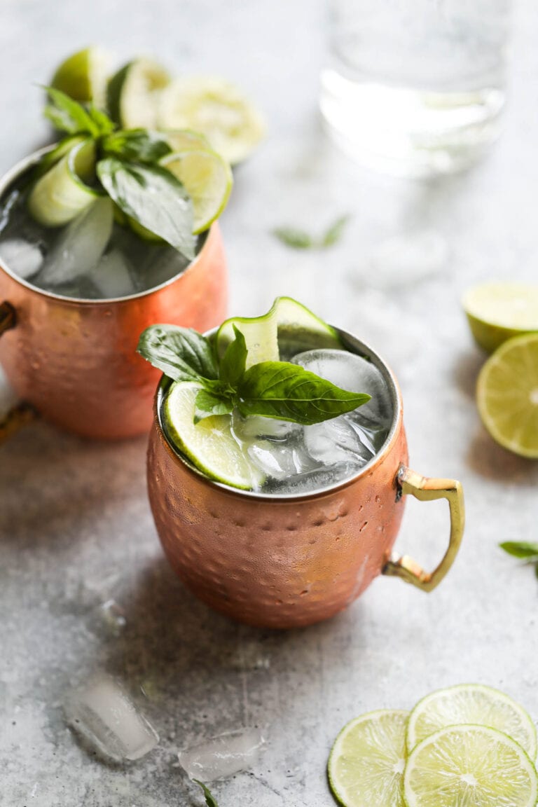Overhead view of cucumber basil Moscow mules in copper mugs topped with fresh basil. 