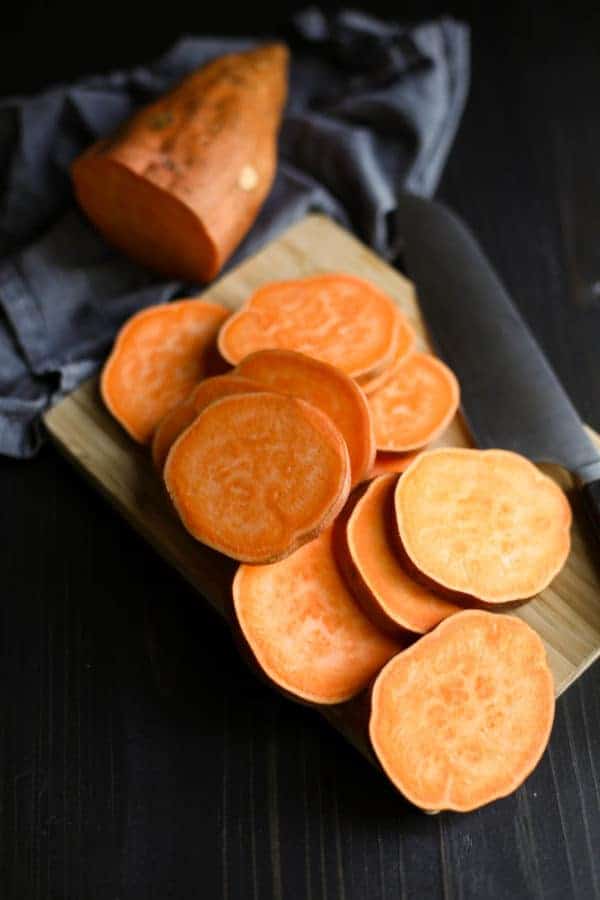 Sweet potato slices on a wooden cutting board