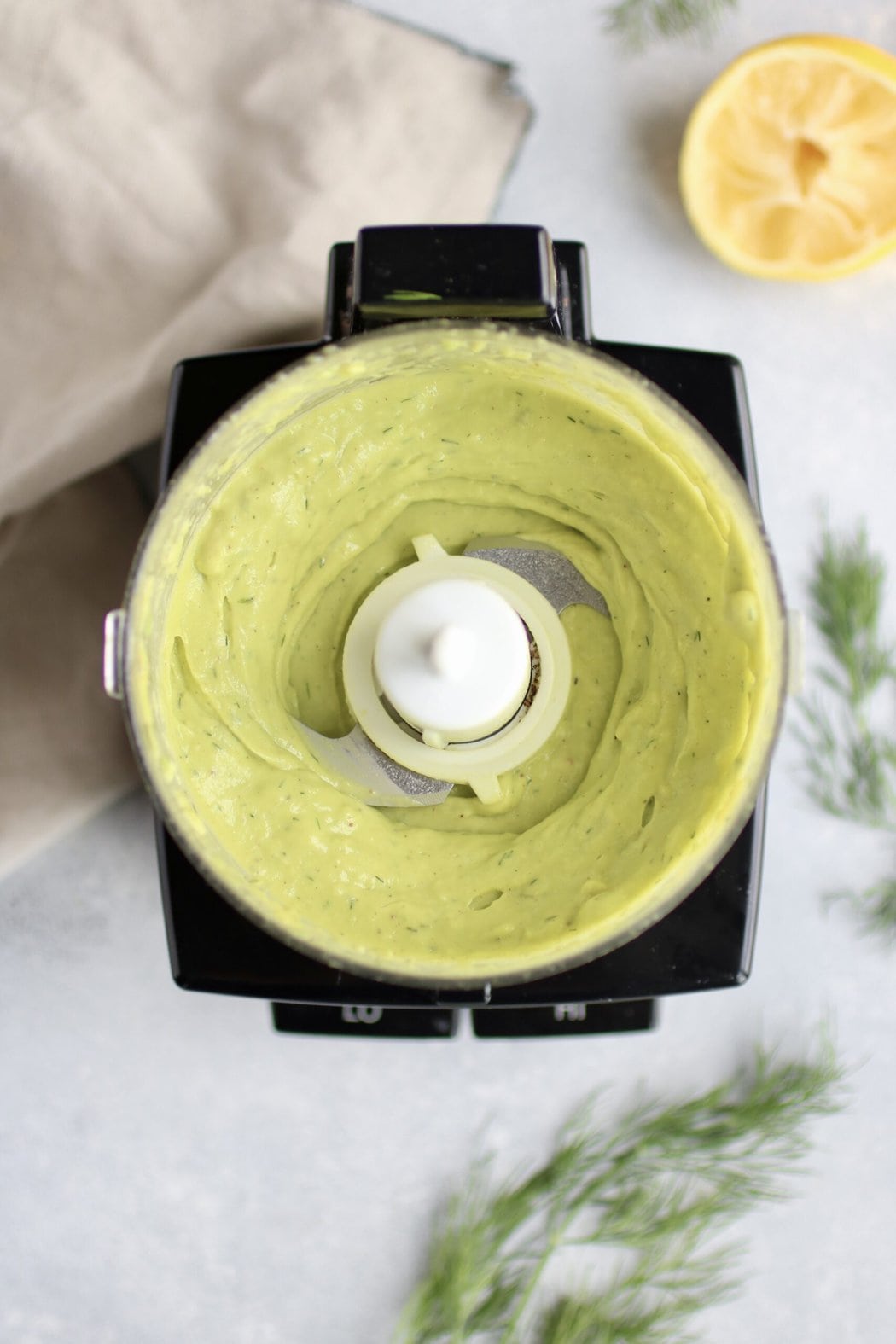 Overhead view small food processor bowl with creamy avocado sauce