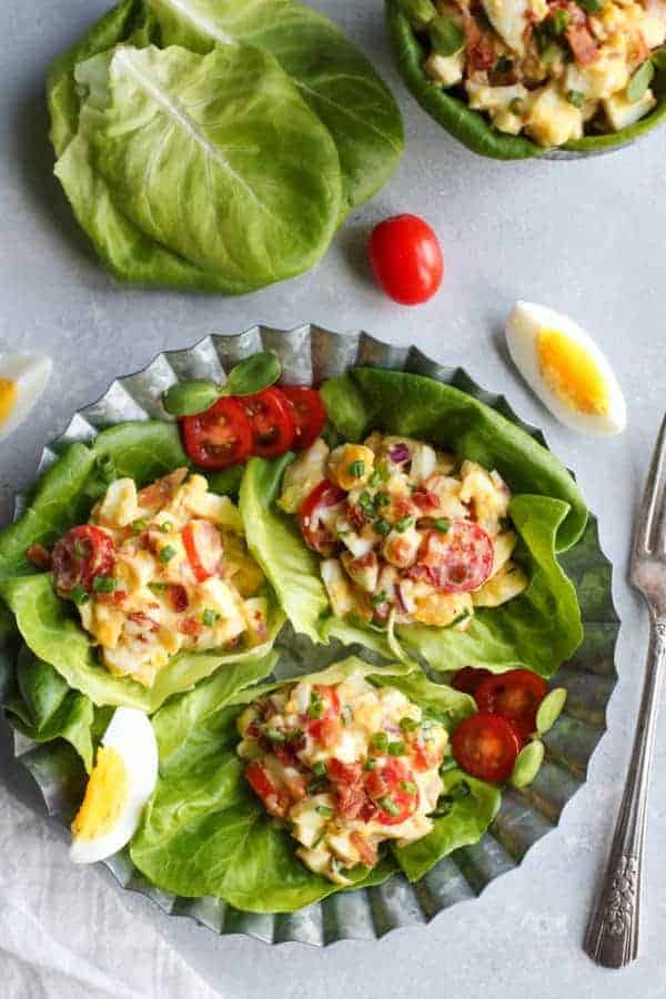 BLT Egg Salad in a lettuce wraps on a plate. 