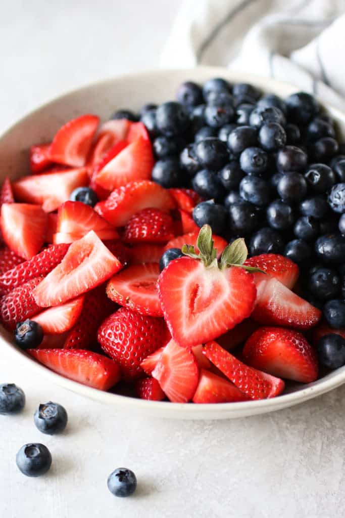 Overhead view of a plate filled with fresh colorful strawberries and blueberries