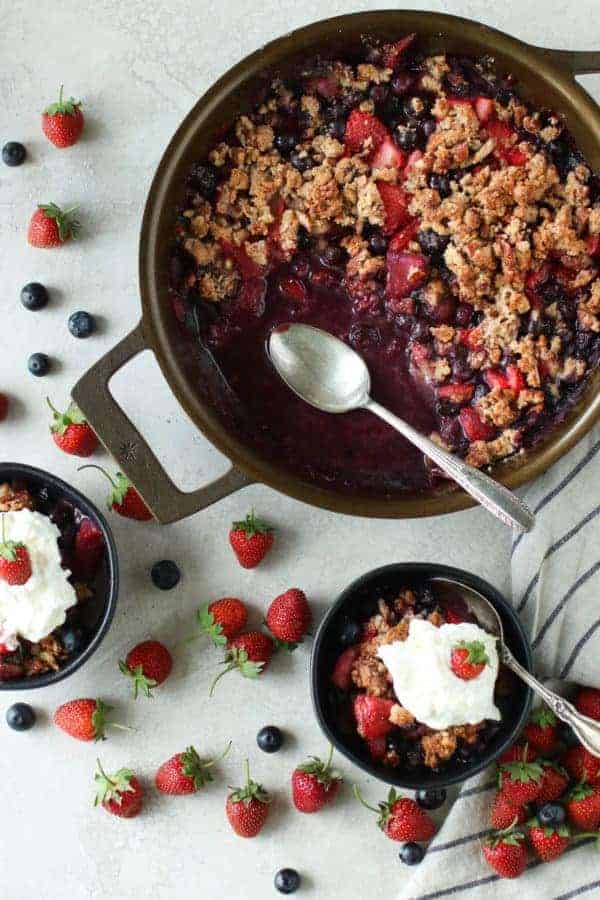 Grain-free berry crisp in a pie dish with a scoop taken out