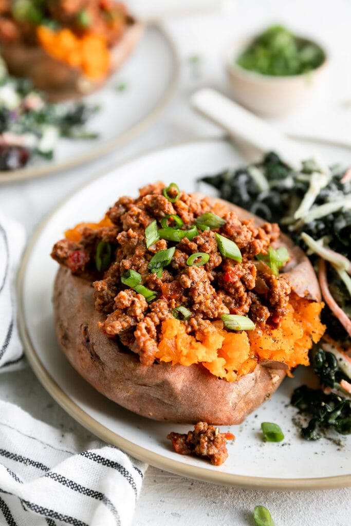 Sloppy joe stuffed sweet potato on plate with side salad