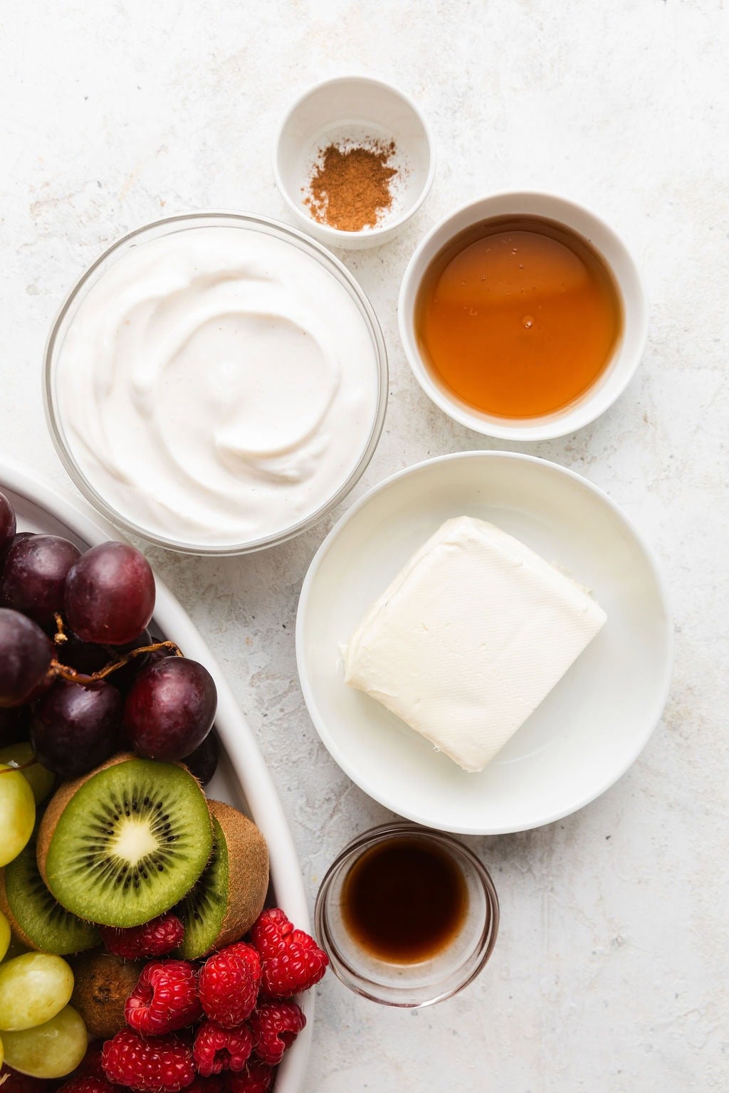 Overhead view of a variety of ingredients for Fruit Dip Recipe in different sized bowls.