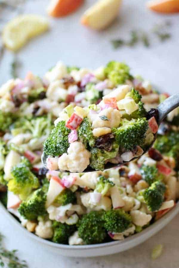 Apple Broccoli Cauliflower Salad on a spoon being lifted towards the camera