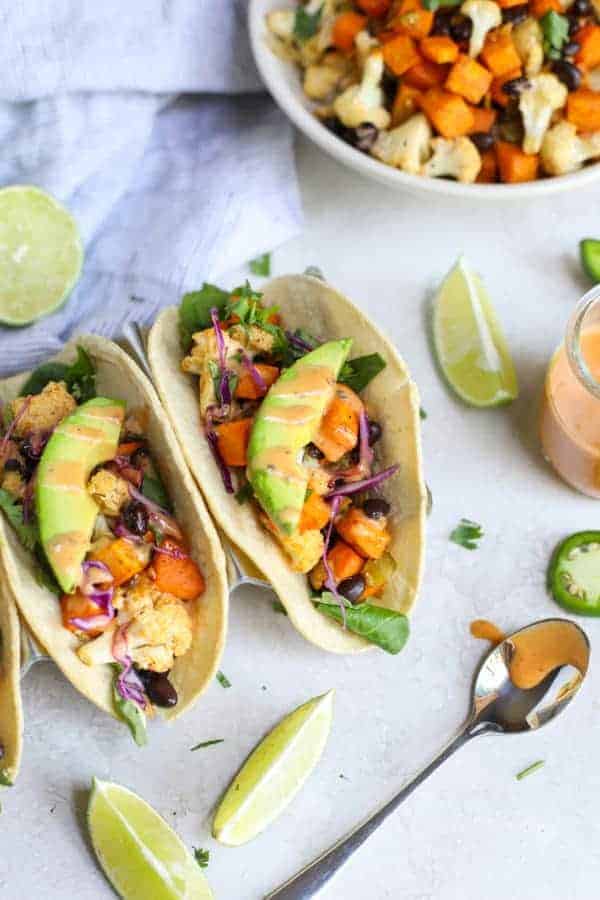 Overhead close up of Vegan Cauliflower Sweet Potato Tacos with avocado and chipotle ranch drizzle. 