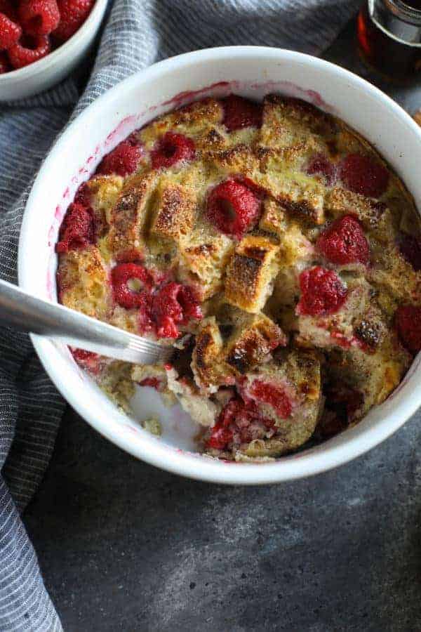 Overhead view of Instant Pot Raspberry French Toast Casserole with a spoon in the dish and a big scoop missing. 