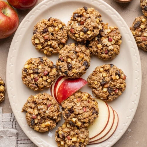 A platter of apple oatmeal cookies with sliced apples.