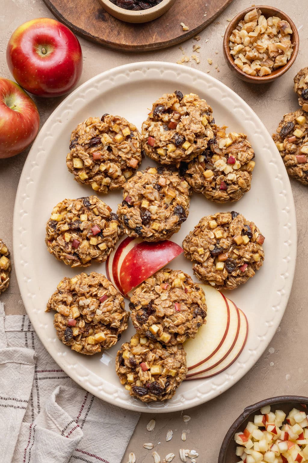A platter of apple oatmeal cookies with sliced apples.